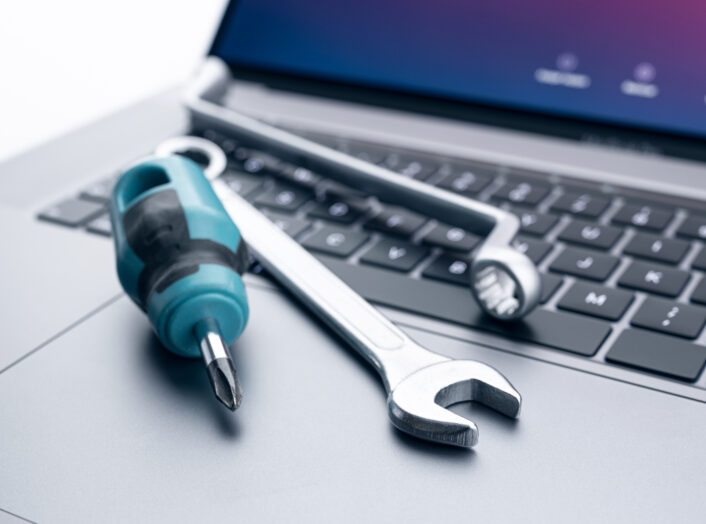 Computer fixing, service or maintenance concept background. Working tools on modern laptop computer
